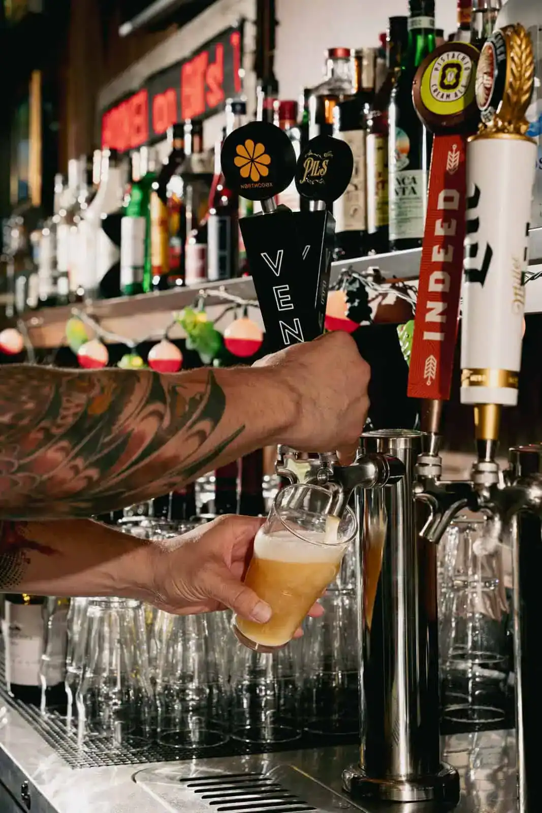 Bartender pouring beer from tap at Bill's Bait Shop, a popular fishing and bait store.